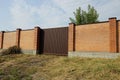 Large brown iron gate and long red brick fence Royalty Free Stock Photo