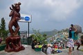 Large brown monkey statue on the left with housing community on the right behind Golden Rock (Kyaiktiyo Pagoda)