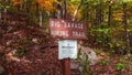 Large, brown sign post in a lush outdoor setting with the text Big savage hiking trail