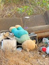Large brown sofa, soft teddy bear are thrown out in trash heap in summer outdoors. Pollution of nature, environment, garbage. Poor