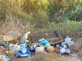 Large brown sofa, soft teddy bear are thrown out in trash heap in summer outdoors. Pollution of nature, environment, garbage. Poor