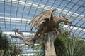 Large brown statue of a dragon inside of Flower Dome, Singapore