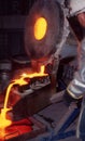 Large bucket of molten gold being poured into ingot molds