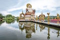 A large Buddha image sits in the middle of the water at Wat Plai Laem on Koh Samui, Sarat Thani Province, Thailand