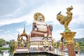 A large Buddha image sits in the middle of the water at Wat Plai Laem on Koh Samui, Sarat Thani Province, Thailand