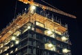 Large Building With Crane on Top, Urban Construction Site Development Progress, A building under construction at night, Royalty Free Stock Photo