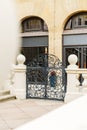 A large building with a gate and a staircase leading up to it. The gate is made of iron and has a decorative design, while the Royalty Free Stock Photo