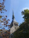 a large building with a steeple and clock tower on top: Mont Saint Michel, France