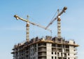 A large building under construction with two cranes on top Royalty Free Stock Photo