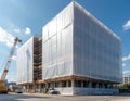 Large building under refurbishment completely covered by construction plastic sheeting over scaffoldings. Crane visible on site. Royalty Free Stock Photo