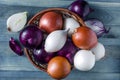 large bulbs of yellow  red and white onions in a wicker basket Royalty Free Stock Photo