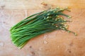 Large bunch of budding Chinese chives on a weathered wood background