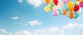 A large bunch of yellow Helium ballons straining on their strings against a sunny sky with white clouds Royalty Free Stock Photo