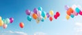 A large bunch of yellow Helium ballons straining on their strings against a sunny sky with white clouds Royalty Free Stock Photo