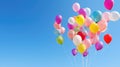 A large bunch of yellow Helium ballons straining on their strings against a sunny sky with white clouds