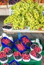 Large bunches of succulent green grapes displayed above tubs of raspberries at Kotor market,Montenegro,Eastern Europe Royalty Free Stock Photo