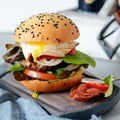 A large burger with a cutlet, vegetables, egg and a fresh roll. Sandwich for breakfast. Fast food. Men`s Food. Royalty Free Stock Photo