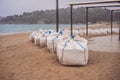 large burlap or hessian sandbags stopping soil erosion on a beach during high tide and stormy days Royalty Free Stock Photo