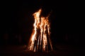 A large burning fire made of sticks against the background of the night sky and the sandy beach Royalty Free Stock Photo