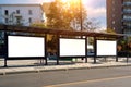 A large bus stop against the background of houses in a modern city with empty advertising banners inside Royalty Free Stock Photo