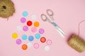 large buttons with threads and scissors on a pink background Royalty Free Stock Photo