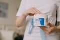 a large can of moisturizer in the hands of a woman cosmetologist-dermatologist. A girl in a medical coat holds a jar of cream