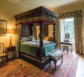 A large canopy bed decorated by carved pillars in one of the rooms inside of Crathes Castle