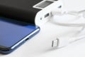 A large and capacious external battery - power bank lies next to the cable, usb type-c connector and a blue smartphone. The