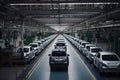 large car factory, with rows of newly assembled vehicles on the assembly line