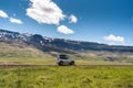 Large car parked on dirt road among the mountain and meadow on sunny day in summer Royalty Free Stock Photo