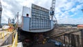 Large Cargo Ship in Dry Dock with Workers and Shipyard Cranes Royalty Free Stock Photo