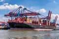 Large cargo vessel docked at a port, with several gantry cranes visible in it