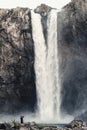 Man at base of waterfall shooting photos