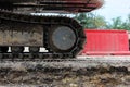 Large caterpillar of excavator on the background plastic enclosures.