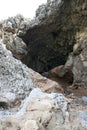 A large cave in the indented cliff. Cliff face, cliffside.