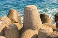 Large cement block breakwater powerful protection of the coastline from the stormy waves of the sea against a background of azure