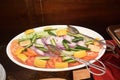 A large ceramic plate of salad dish with fork tongs laid out for serving Royalty Free Stock Photo