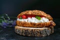 Large cereal croissant with cottage cheese and fresh strawberries on a dark background. Tasty breakfast. Royalty Free Stock Photo