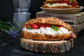 Large cereal croissant with cottage cheese and fresh strawberries on a dark background. Tasty breakfast. Royalty Free Stock Photo