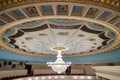 Large chandelier hangs on the theater hall decorated ceiling Royalty Free Stock Photo