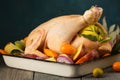 A large chicken stuffed with an apple with vegetables and citrus fruits