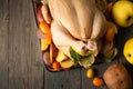 A large chicken stuffed with an apple with vegetables and fruits, top view