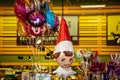 Large Christmas elf helium balloon floating near a bunch of other party balloons in a store