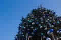 A large Christmas tree decorated with a star and round balls on a blue sky background. Royalty Free Stock Photo