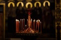 On a large Church copper candlestick lit a small candle. Orthodox Christian Church. Religion