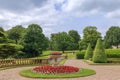 Large circular flower bed with Edwardian tazza stone planter in a landscaped English park. Royalty Free Stock Photo