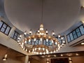 A large circular mosque chandelier ceiling light with lamps and made of copper and other metals fixed to the large mosque masjid