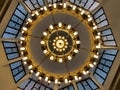 A large circular mosque chandelier ceiling light with lamps and made of copper and other metals fixed to the large mosque masjid Royalty Free Stock Photo