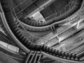 Large circular stairs leading up inside a multi-story building (monochrome