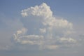 a large cirrocumulus cloud illuminated by the sun\'s rays in the blue sky Royalty Free Stock Photo